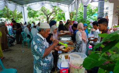 MUNTOK, İNDONEZYA - 17 Nisan 2023: Aile etkinliğinde yiyecek alan bir kalabalık