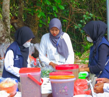 MUNTOK, INDONEZYA - 10 Eylül 2023: Kadınlar Endonezya 'nın Rambat Köyündeki Geleneksel Bir Partide Sofrada Yemek Hazırlamakla meşgul