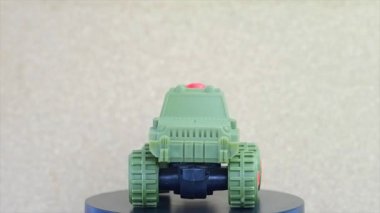 Yeşil Plastikten yapılma oyuncak askeri araba, Dönen Hareket görünümlü.