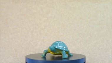 Turkuaz Rubber 'dan yapılmış bir oyuncak kaplumbağa. Dönen video ekranı var.