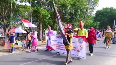 MUNTOK, Indonezya - 15 Eylül 2023: Endonezya 'nın Bağımsızlık Günü' nde Eşsiz Kostüm Değişiklikleriyle Öğrenci Karnaval Katılımcılarının Eşi