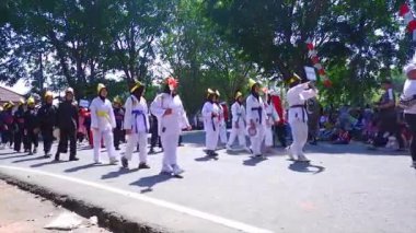 MUNTOK, Indonezya - 15 Eylül 2023: Siyah ve Beyaz Kostümlü Silat Sporcuları Karnaval Yürüyüşü, Endonezya 'nın Bağımsızlık Günü' nde