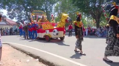 MUNTOK, İNDONEZYA - 15 Eylül 2023: Endonezya 'nın Bağımsızlık Günü' nde Şamandıralı ve renkli kostümlü karnaval katılımcıları geçidi