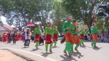 MUNTOK, İNDONEZYA - 15 Eylül 2023: Geleneksel Yeşil Malay kostümleri giyen bir grup Karnaval katılımcısı, Endonezya Bağımsızlığının Yıldönümünü Kutlarken