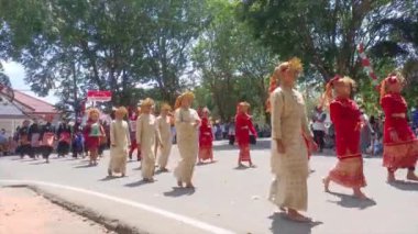 MUNTOK, İNDONEZYA - 15 Eylül 2023: Geleneksel Malay kostümleri giyen bir grup Karnaval katılımcısının eşleşmesi, Endonesi Cumhuriyeti 'nin Bağımsızlık Günü' nün Kutlaması sırasında