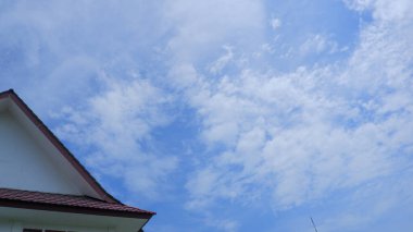 Arkaplanda parlak mavi gökyüzü olan bir ofis binasının çatısı.