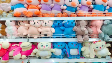 Düzgünce düzenlenmiş ve bir minimarket rafında sergilenmiş çeşitli güzel bebekler.