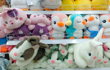 Oyuncak bebek dükkanında sergilenen, düzgünce ve sıkıca yerleştirilmiş çeşitli şirin oyuncak bebek çeşitleri.