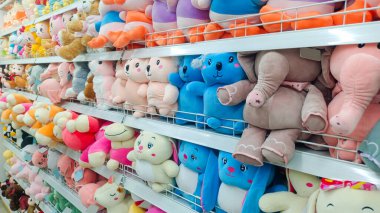 Minimarket rafta sıkıca ve düzgünce dizilmiş çeşitli güzel oyuncak bebek çeşitleri.
