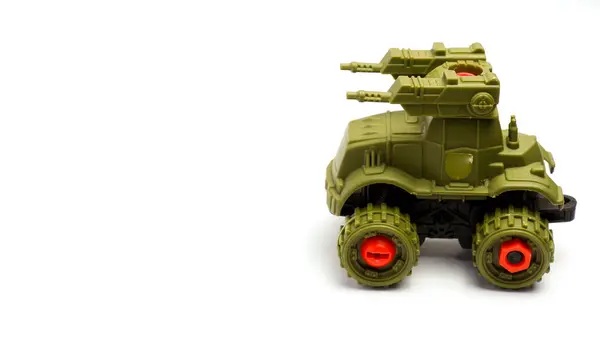 Askeri savaş tankı şeklinde, beyaz arka planda yeşil renkli bir çocuk oyuncağı. Kompozisyonu ile izole edilmiş, sol tarafta boşluk bırakılmış.