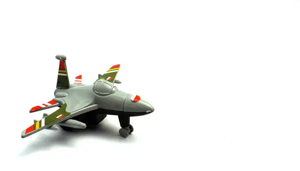 İzole edilmiş beyaz arkaplanı olan, uçak şeklinde bir çocuk oyuncağı. 3. sınıf fotoğraf kompozisyonu.