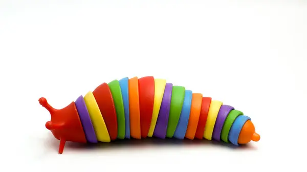 Salyangoz şeklinde bir çocuk oyuncağı. Beyaz bir arka planı var. Üçüncü kompozisyonun kuralını kullanarak izole edilmiş ve fotoğraflanmış.