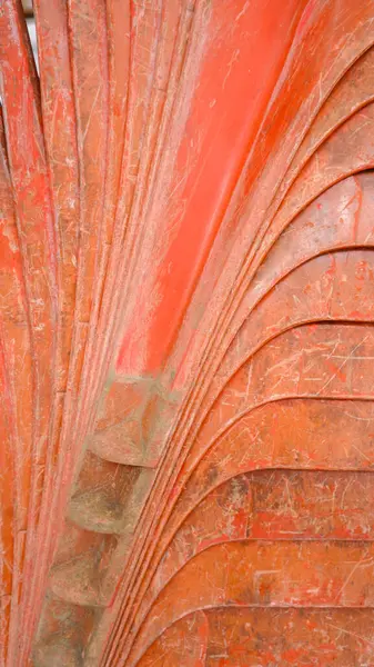 Turuncu plastik koltuğun bacakları, düzgün yerleştirilmiş ve sıkıca yerleştirilmiş, portre modunda çekilmiş fotoğraf.