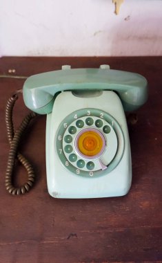 Daha basit bir Yeşil Rotary Phone. Telefon hafifçe eğik, mahremiyet hissi yaratıyor ve izleyiciyi alıcıyı alması için davet ediyor..