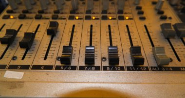 Close-up Of An Analog Audio Mixer, Featuring Faders, Knobs, And Channel Strips. The Mixer Is In A Worn Condition, Indicating That It Has Been Used For Many Years. clipart