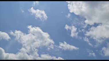 Açık Mavi Gökyüzü Panoraması 'nın 4k' lik hiperlapse görüntüsü. Orta büyüklükte beyaz bulutlar eşit olarak dağılmış. Yumuşak Güneş ışığı bulutların arasından parlar ve çarpıcı bir üç boyutlu etki yaratır.
