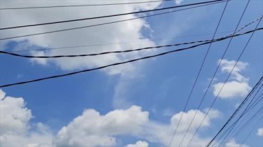 Kümülüs Bulutlu Mavi Bir Gökyüzünün Yüksek Açılı 4k Hızlandırılmış Görüntüsü, Karmaşık Güç Hatları Ağı ile Karıştırılmış