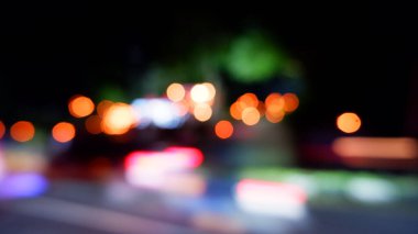 Gecenin bir yarısı şehrin bir köşesindeki trafik akışının odak dışı fotoğrafı.