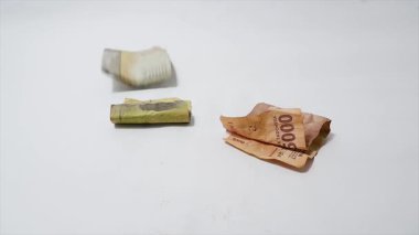 İzole edilmiş beyaz arka planda çeşitli renk ve değerlerden oluşan dağınık rupiah banknotlarının görüntüleri