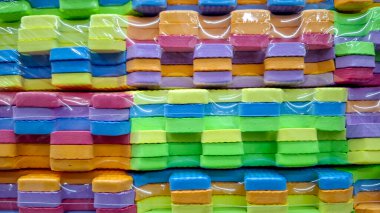 Birbirlerine kenetlenmiş renkli köpük minder yığınlarının yakın görüntüsü. Her yığın, sarı, yeşil, mavi, pembe ve mor renklerin ayırt edici bir kombinasyonunu gösterir.