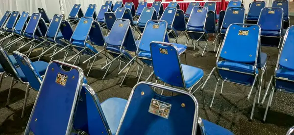 Bir dizi krom çerçeveli mavi metal sandalye koleksiyonu, halk etkinliklerinde, okul toplantılarında ya da kapalı alanlarda kullanılır..