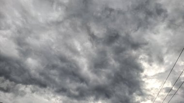 Yoğun fırtına bulutlarıyla dolu karanlık ve bulutlu bir gökyüzünün dramatik görüntüsü, yağmurun ya da fırtınanın geldiğini gösteriyor..