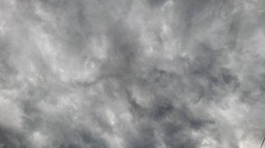 Yoğun ve fırtınalı bulutlarla dolu çok bulutlu bir gökyüzünün çarpıcı bir fotoğrafı. Dönen oluşumlar ve gri renkler dramatik ve atmosferik bir sahne yaratır..