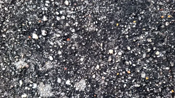 Yüksek çözünürlüklü asfalt kaldırım fotoğrafı görünür çakıl ve kaba siyah yüzeyi gösteriyor
