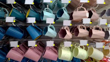 Bu resim, perakende mağaza rafında modern plastik bardakların düzenli bir seçimini gösterir