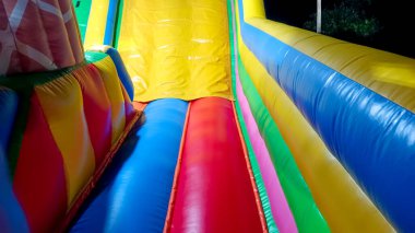 Açık hava eğlence alanında gece çekilen renkli şişirilebilir bir slaytın canlı, yakın çekim görüntüsü..