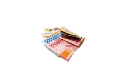 Bin, iki bin, beş bin, elli bin ve yüz bin IDR dahil olmak üzere farklı değerlerde Endonezya Rupiah banknotları, beyaz bir arka planda düzenlenmiştir..