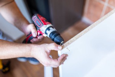 Male Using Self-Assembly Kit Making Cabinet