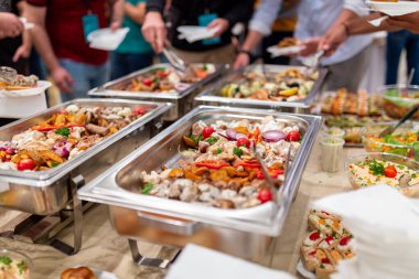 Close up of buffet table food in chafing dish at celebration event.