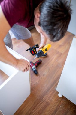 İşinin ehli. Mutfak raflarının kablosuz tornavidayla tamir edilmesi veya kurulması