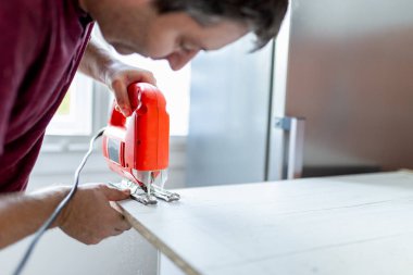 Marangoz mutfak elementlerini monte ederken yapboz makinesi kullanıyor