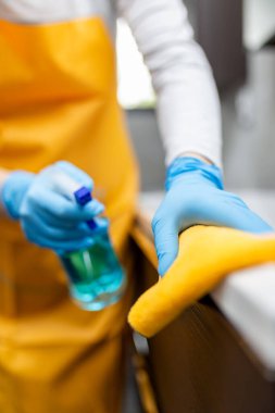 Kadınlar evlerinde dezenfekte edilmiş sıvı sprey şişesi ve bezle angarya işler yapıyorlar..