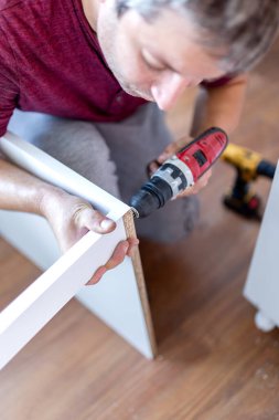 Male Using Self-Assembly Kit Making Cabinet