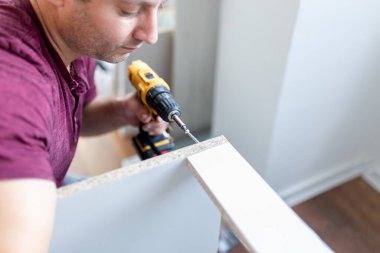 Elektrikli tornavidalı bir adam. Mutfak montaj konsepti.