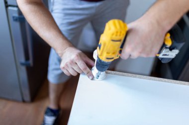 Marangoz mutfak elementleri kurulumu için elektrik kablosuz tornavida kullanıyor