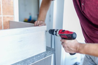 Mutfak işçilerinin kablosuz matkapla ahşap elementleri birleştirmesi..