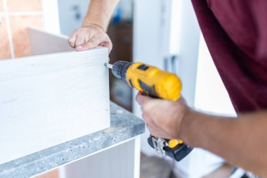 Mutfak işçisi, ahşap elementleri kablosuz tornavida matkabıyla birleştiriyor..