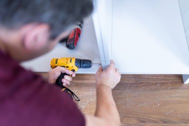 Mutfak işçisi, ahşap elementleri kablosuz tornavida matkabıyla birleştiriyor..