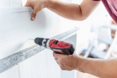 Mutfak işçilerinin kablosuz matkapla ahşap elementleri birleştirmesi..