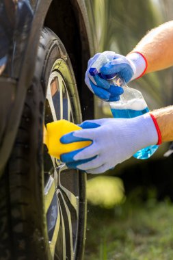 Erkek işçi araba alaşımlı tekerleği yıkıyor..