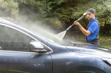 Çalışan işçiler dışarıda araba yıkarlar.