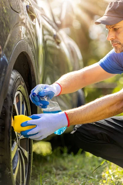 Erkek işçi araba alaşımlı tekerleği yıkıyor..