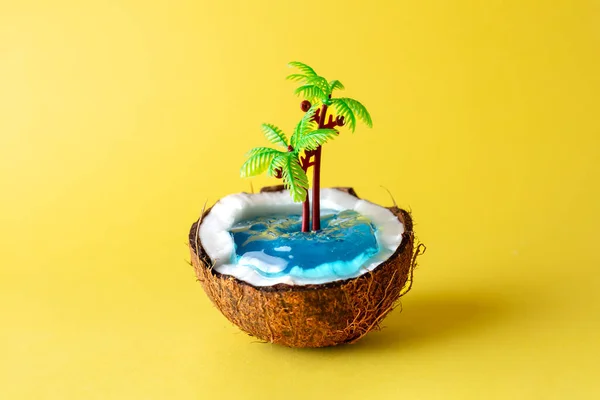 Coconut tropical island on yellow background. Summer beach concept made of coconut fruit and palm trees. Creative minimal idea.
