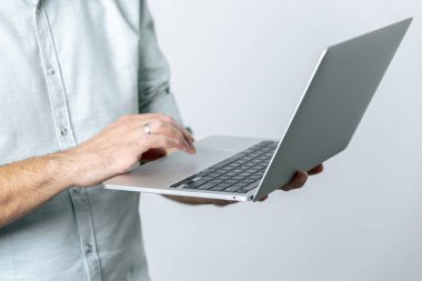 Beyaz arkaplana karşı dizüstü bilgisayarı tutan adamı kapat ve kullan.