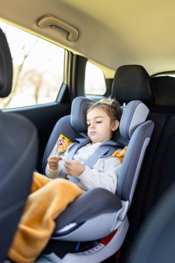 Bebek koltuğunda oturan tatlı kız. Çocuklar ve seyahat kavramı.