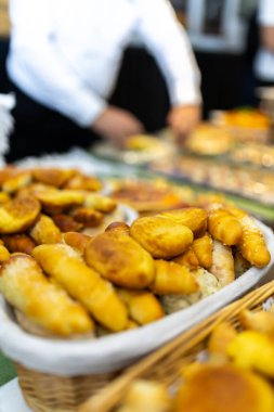 Altın hamur işlerinin canlı bir yayılımı, canlı bir gıda pazarındaki büyük ve ilgi çekici ziyaretçileri dolduruyor. Aşçılar arka planda koşuşturur, daha fazla zevk hazırlar..